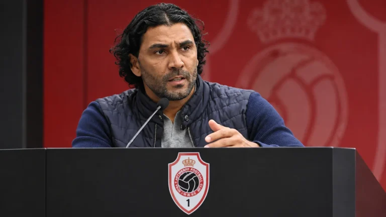 Marvin Compper spreekt op een persconferentie achter een lessenaar met het Antwerp-embleem.