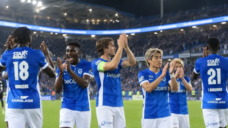 Een groep KRC Genk-spelers applaudisseert in de Cegeka Arena onder de verlichte LED-ring.