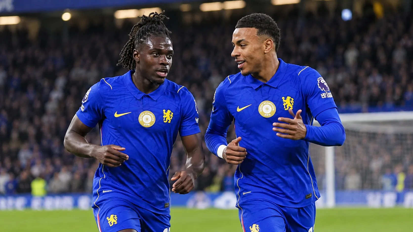 Twee Chelsea-spelers in blauwe tenues in actie tijdens een wedstrijd.