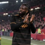 Tolu Arokodare applaudisseert in het zwarte Ajax-tenue richting de tribunes.