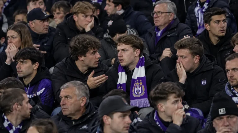Een groep Anderlecht-supporters reageert in de tribune met een paars-witte sjaal zichtbaar tussen de fans.
