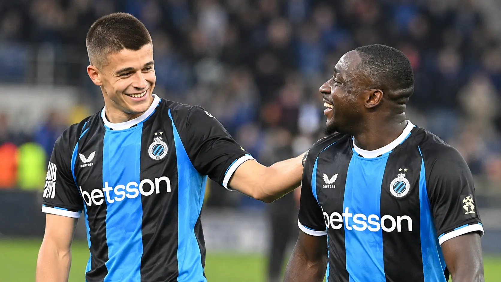Twee Club Brugge-spelers vieren samen op het veld.