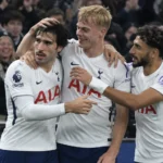 Tottenham-spelers vieren samen een doelpunt voor de tribune.