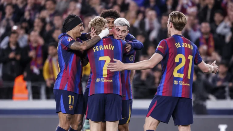 Een groep spelers van FC Barcelona in blauw-rood gestreepte tenues tijdens een wedstrijdmoment.