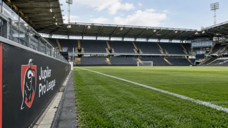 Leeg Jupiler Pro League-stadion met een competitiebord langs het veld.