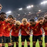 Spelers van de Belgische nationale ploeg verzamelen in een huddle op het veld.