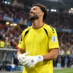 Vozinha in geel doelmanstenue aan de zijlijn van een stadion