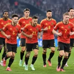 Belgische internationals in rode tenues tijdens een gezamenlijke opwarming op het veld.