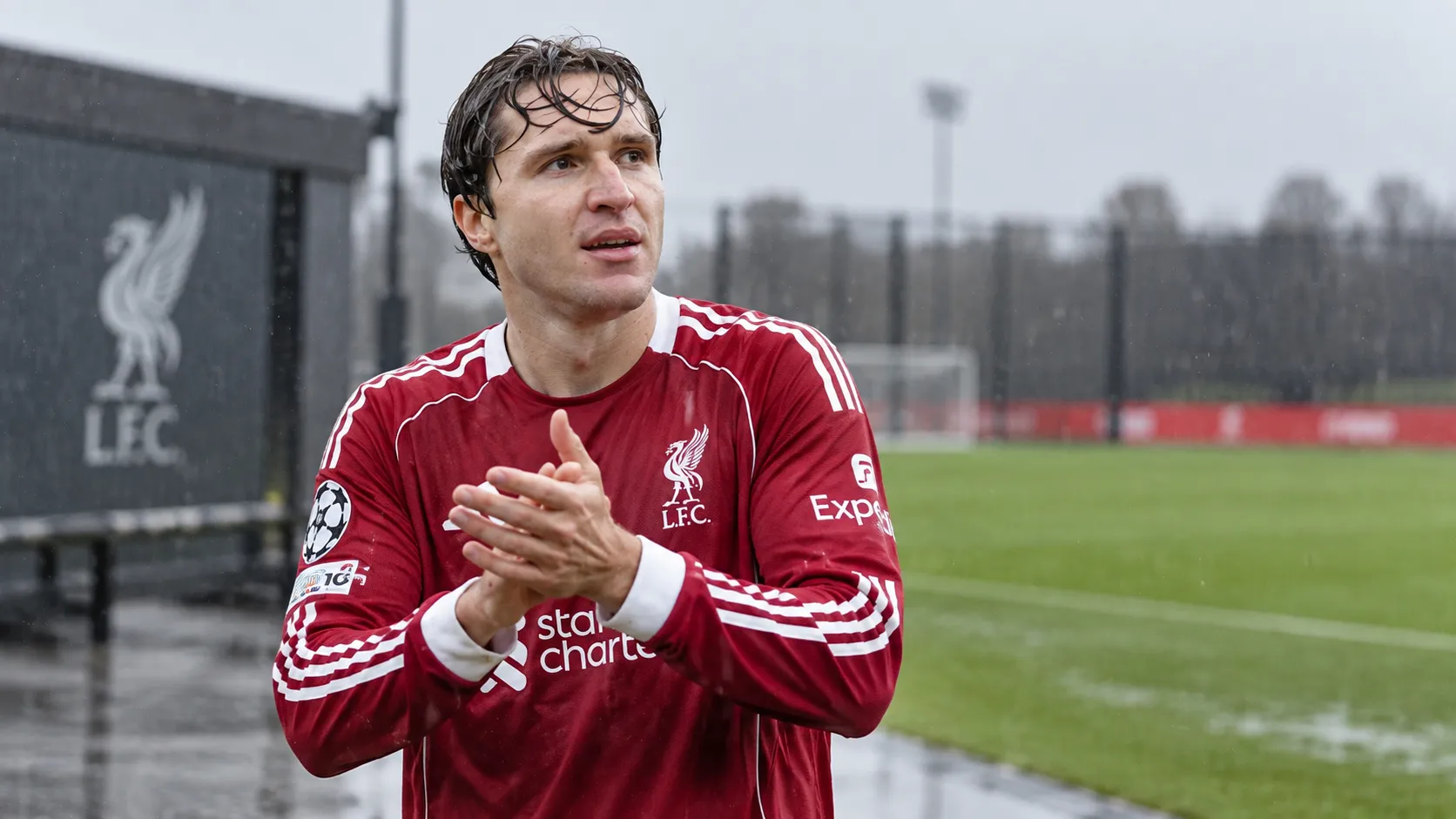 Federico Chiesa in Liverpool-tenue naast een nat trainingsveld.