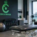 Lege herstelruimte van Cercle Brugge met een clubembleem op de muur.