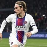 Mika Godts in het witte tenue van Paris Saint-Germain tijdens een wedstrijdmoment.