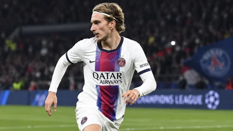 Mika Godts in het witte tenue van Paris Saint-Germain tijdens een wedstrijdmoment.