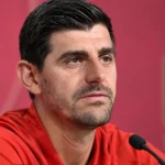 Thibaut Courtois tijdens een persmoment in rode Belgische sportkleding.