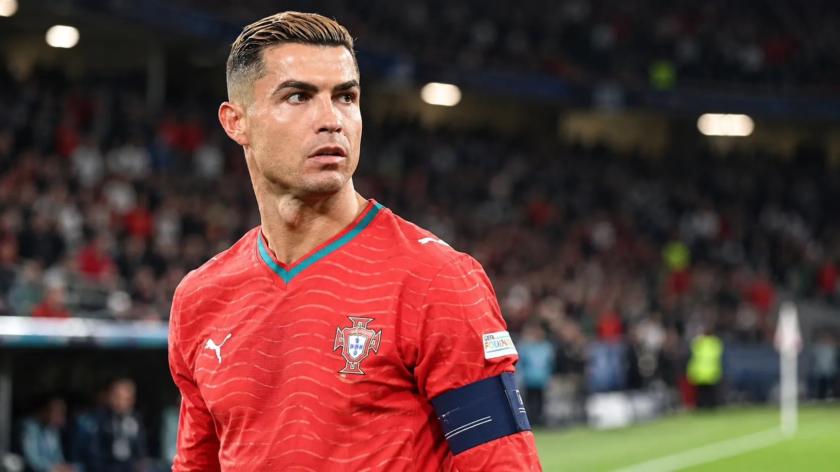 Cristiano Ronaldo in het rode shirt van Portugal tijdens een interland in een stadion.