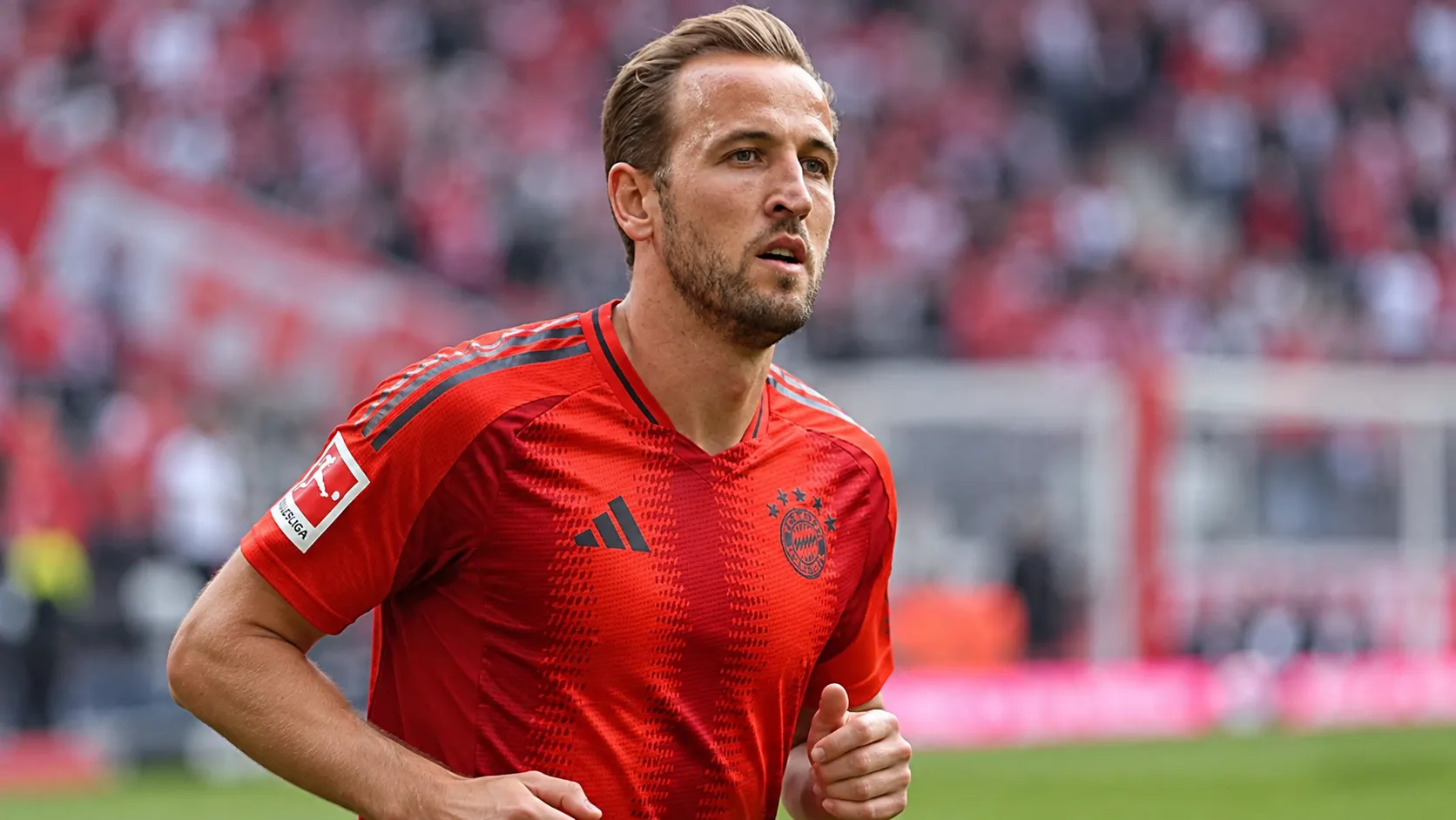 Harry Kane warmt op in het rode shirt van Bayern München.