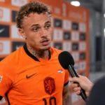 Noa Lang in het oranje shirt van Nederland tijdens een interview in de mixed zone.
