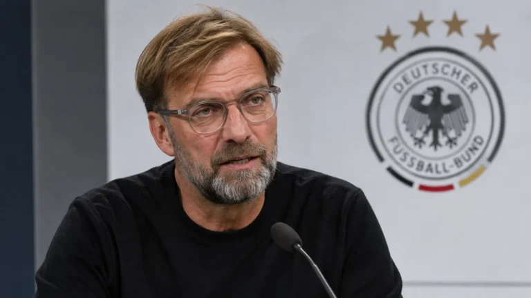 Jürgen Klopp spreekt in een interviewzone met een Duits nationaal ploegembleem op de achtergrond.