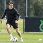 Hannes Van Der Bruggen op het trainingsveld van Cercle Brugge, met een clubbord op de achtergrond.