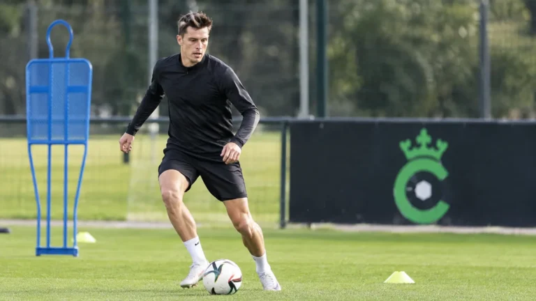 Hannes Van Der Bruggen op het trainingsveld van Cercle Brugge, met een clubbord op de achtergrond.