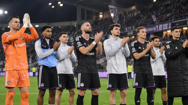 Een groep Anderlecht-spelers applaudisseert na een wedstrijd voor de supporters.