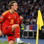 Mika Godts in een rood Belgisch tenue tijdens een opwarming aan de zijlijn van het Stade de France.