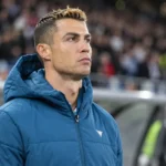 Cristiano Ronaldo in een blauwe Portugal-jas langs de rand van het stadion.