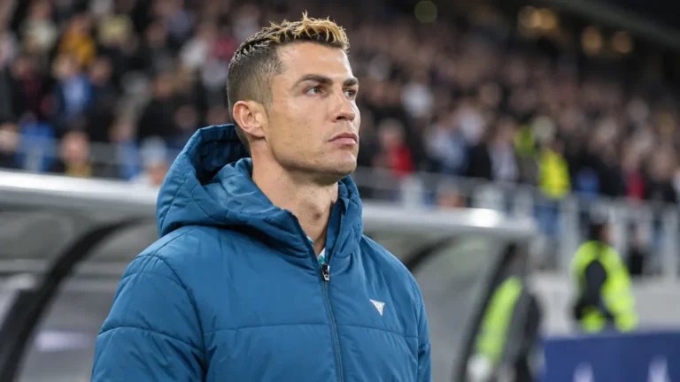 Cristiano Ronaldo in een blauwe Portugal-jas langs de rand van het stadion.