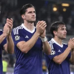 Een groep Anderlecht-spelers in paarse shirts applaudisseert samen in het stadion.