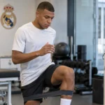 Kylian Mbappé in neutrale sportkleding in een herstelruimte van Real Madrid.