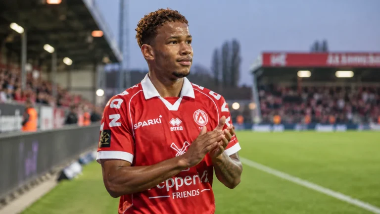 Shandre Campbell in het rode shirt van KV Kortrijk aan de rand van een voetbalveld.