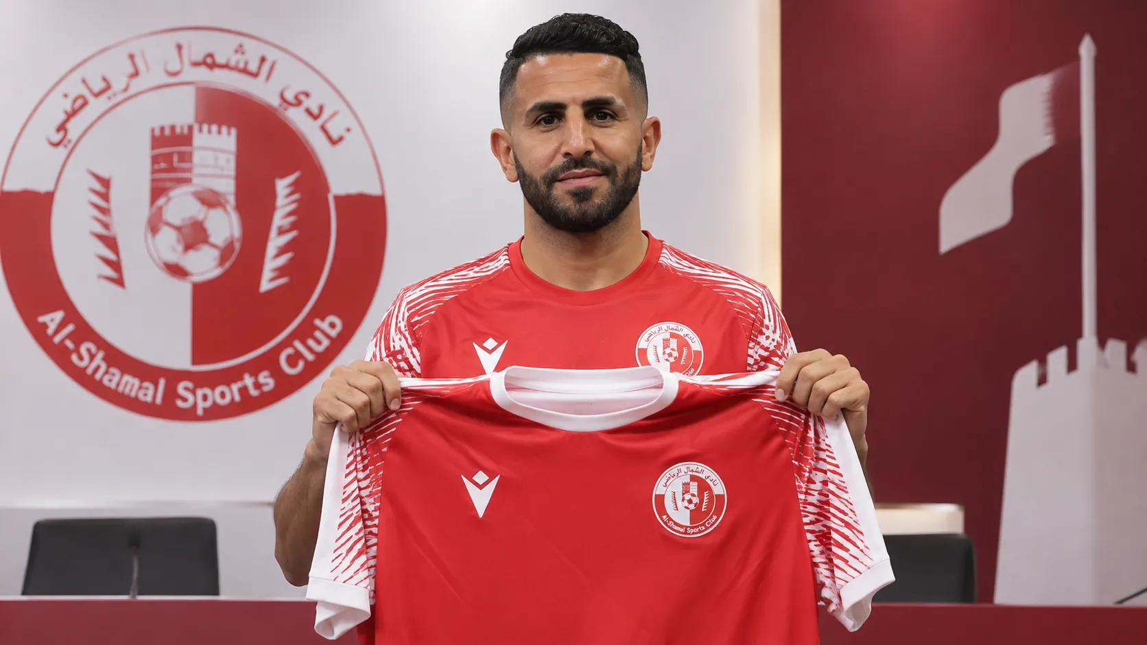 Riyad Mahrez poseert met het shirt van Al-Shamal tijdens zijn officiƫle voorstelling.