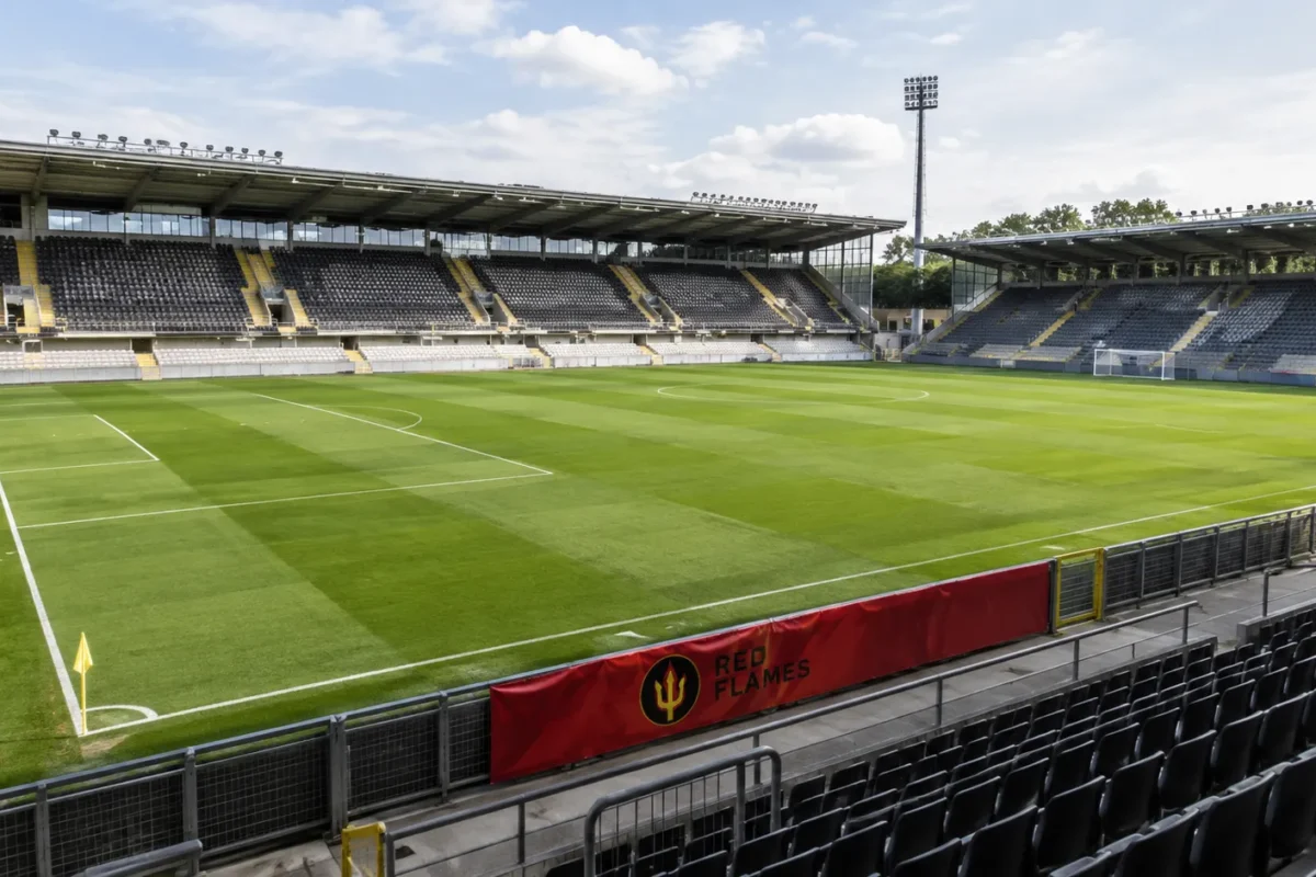 Leeg voetbalstadion met een Red Flames-spandoek langs het veld.