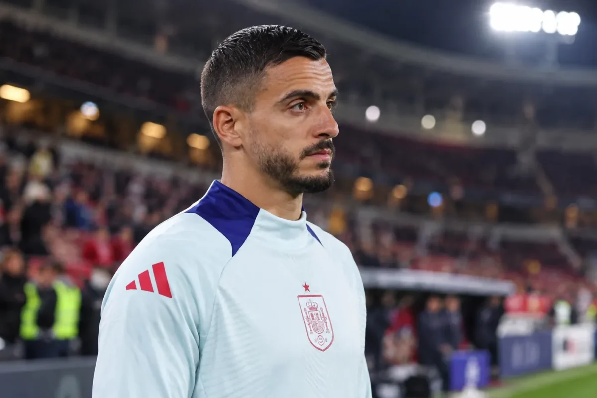 Joselu in een lichtblauw trainingsshirt van Spanje aan de rand van het veld.