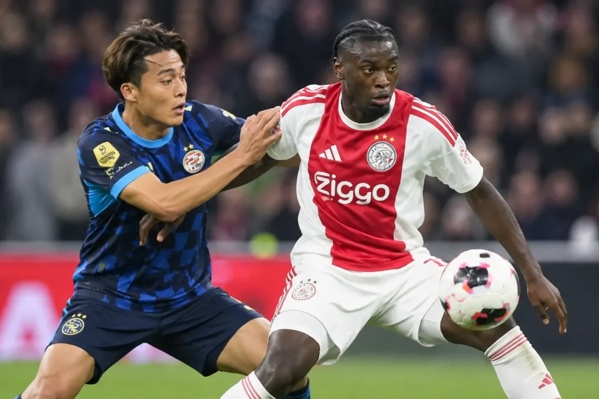 Jorthy Mokio in actie in het rood-witte shirt van Ajax tijdens een voetbalwedstrijd.