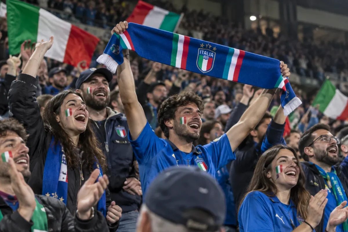 Een collectieve groep Italiaanse supporters viert in de tribune na een Nations League-zege.
