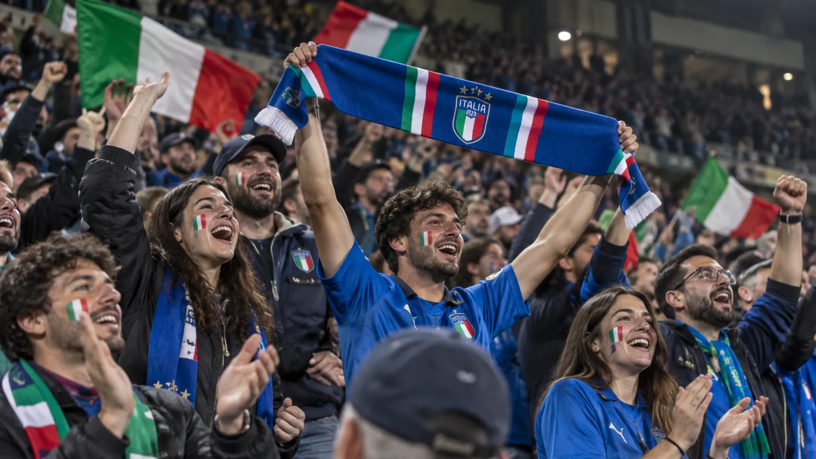 Een collectieve groep Italiaanse supporters viert in de tribune na een Nations League-zege.