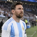 Lionel Messi in het shirt van Argentinië aan de zijlijn van een stadion.