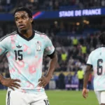 Nathan Ngoy staat na de wedstrijd op het veld van het Stade de France naast een Belgische ploegmaat.