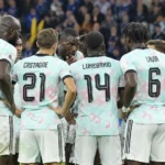 Belgische internationals in lichte wedstrijdshirts die zich op het veld groeperen.