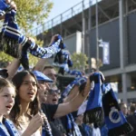 Een groep Club Brugge-supporters zwaait met blauw-zwarte sjaals buiten het stadion.