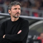 Mark van Bommel kijkt geconcentreerd vanuit de technische zone van een interlandstadion.