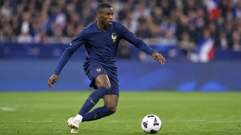 Ousmane Dembélé in het donkerblauwe tenue van Frankrijk met de bal aan de voet.