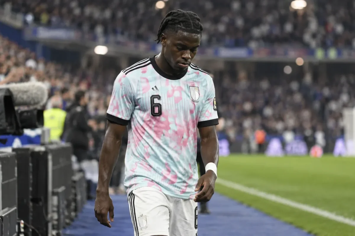 Romeo Lavia wandelt in een wit wedstrijdtenue op het veld na een interland.