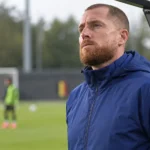 Gill Swerts staat aandachtig langs de zijlijn bij een voorbereiding van België U21.