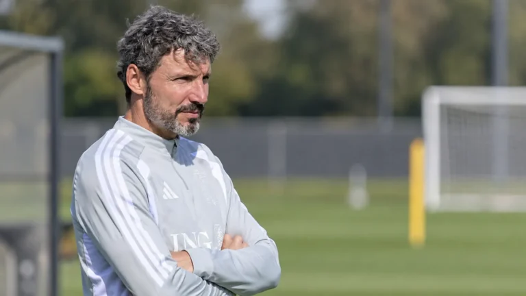 Mark van Bommel langs een trainingsveld in een lichtgrijze trainingstop.