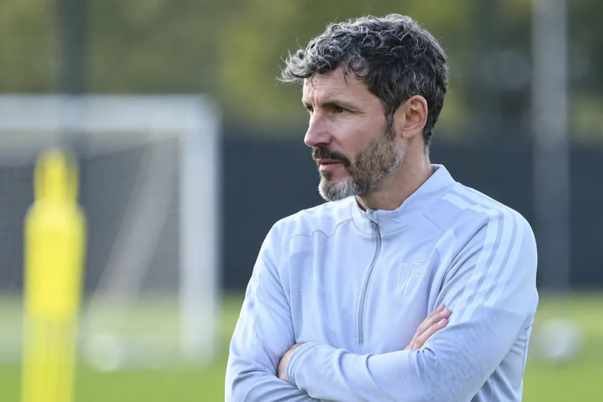 Mark van Bommel observeert aandachtig langs een oefenveld.