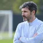 Mark van Bommel observeert aandachtig langs een oefenveld.