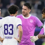 Een groep spelers van RSC Anderlecht verzamelt zich na een wedstrijd op het veld.
