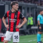 Alexis Saelemaekers staat rustig langs de zijlijn in het tenue van AC Milan.
