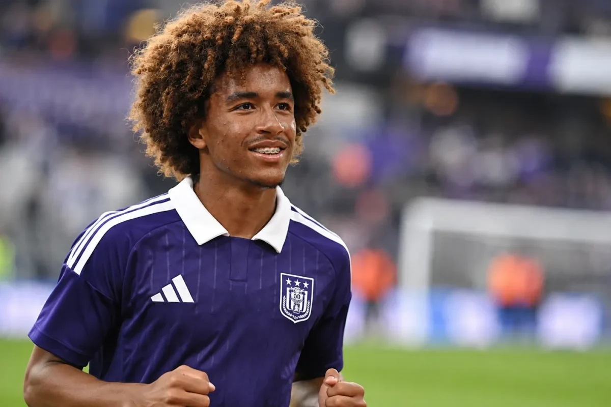 Een jonge Anderlecht-speler in paars tenue tijdens een rustige warming-up op het veld.
